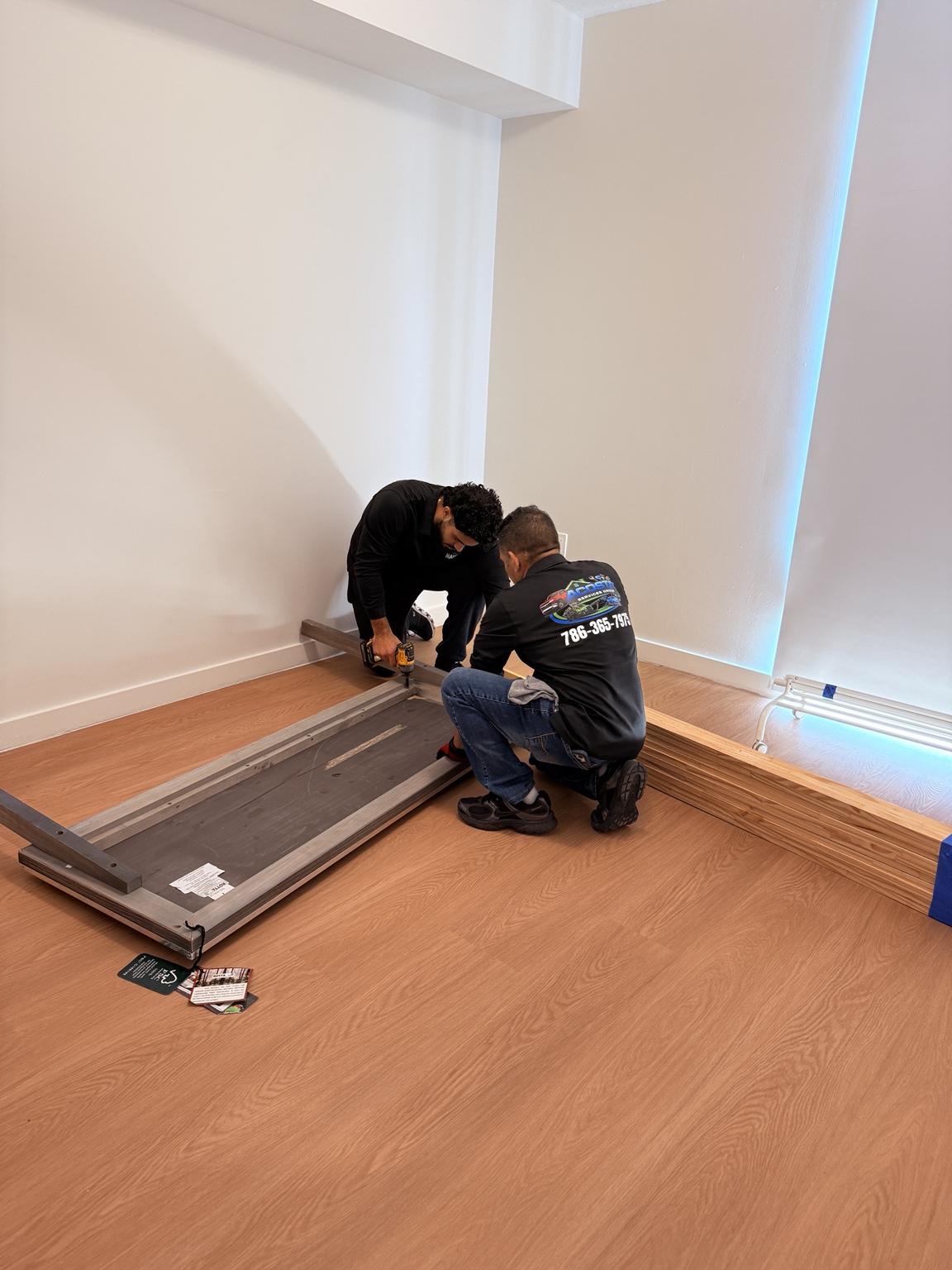 Father-and-son Acosta team assembling furniture in a client's home